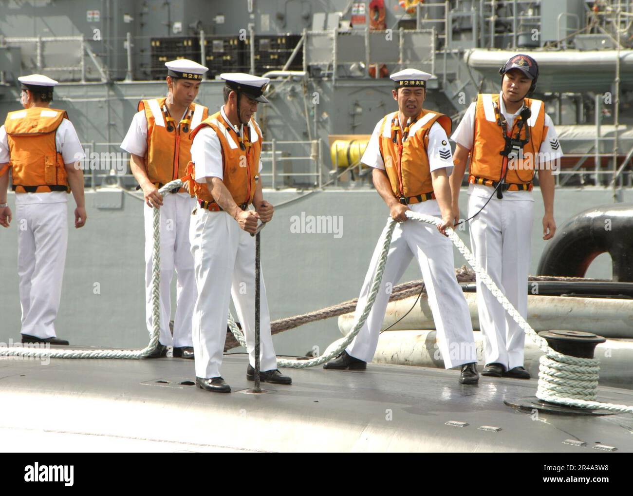 US Navy Line handlers aboard the Japanese submarine Narushio (SS 595) secure lines after arriving in Pearl Harbor, Hawaii for a port call Stock Photo