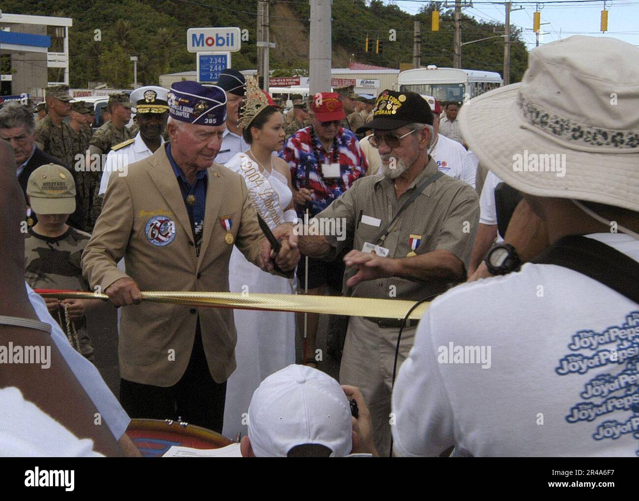 US Navy Retired WWII veteran, U.S. Marine Corps Colonel Fraser West, left, prepares to cut the