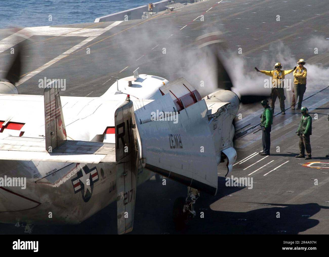US Navy Aviation Boatswain's Mates direct a C2A Greyhound onto one of
