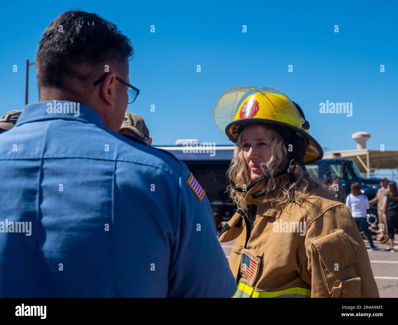 Karen Longo, 756th Aircraft Maintenance Squadron honorary commander, speaks with a member of the Luke Air Force Base Fire Department March 24, 2023, at Luke AFB, Arizona. Longo had the opportunity to try on the turnout gear worn by Luke AFB firefighters during a familiarization event. Stock Photo
