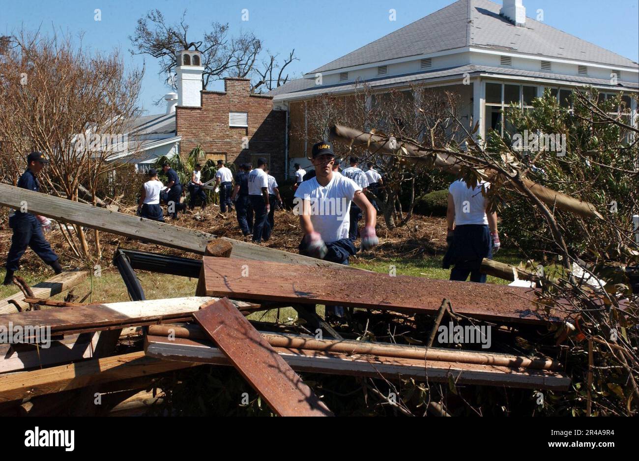 US Navy Students assigned to the Naval Air Technical Training Center (NATTC) on board Naval Air Station Pensacola, Fla., work together to clear debris left by Hurricane Ivan Stock Photo