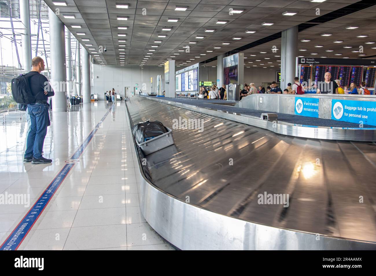 BANGKOK, THAILAND, JAN 20 2023, Passengers are waiting for their luggage on the conveyor in the arrivals hall of the airport Stock Photo