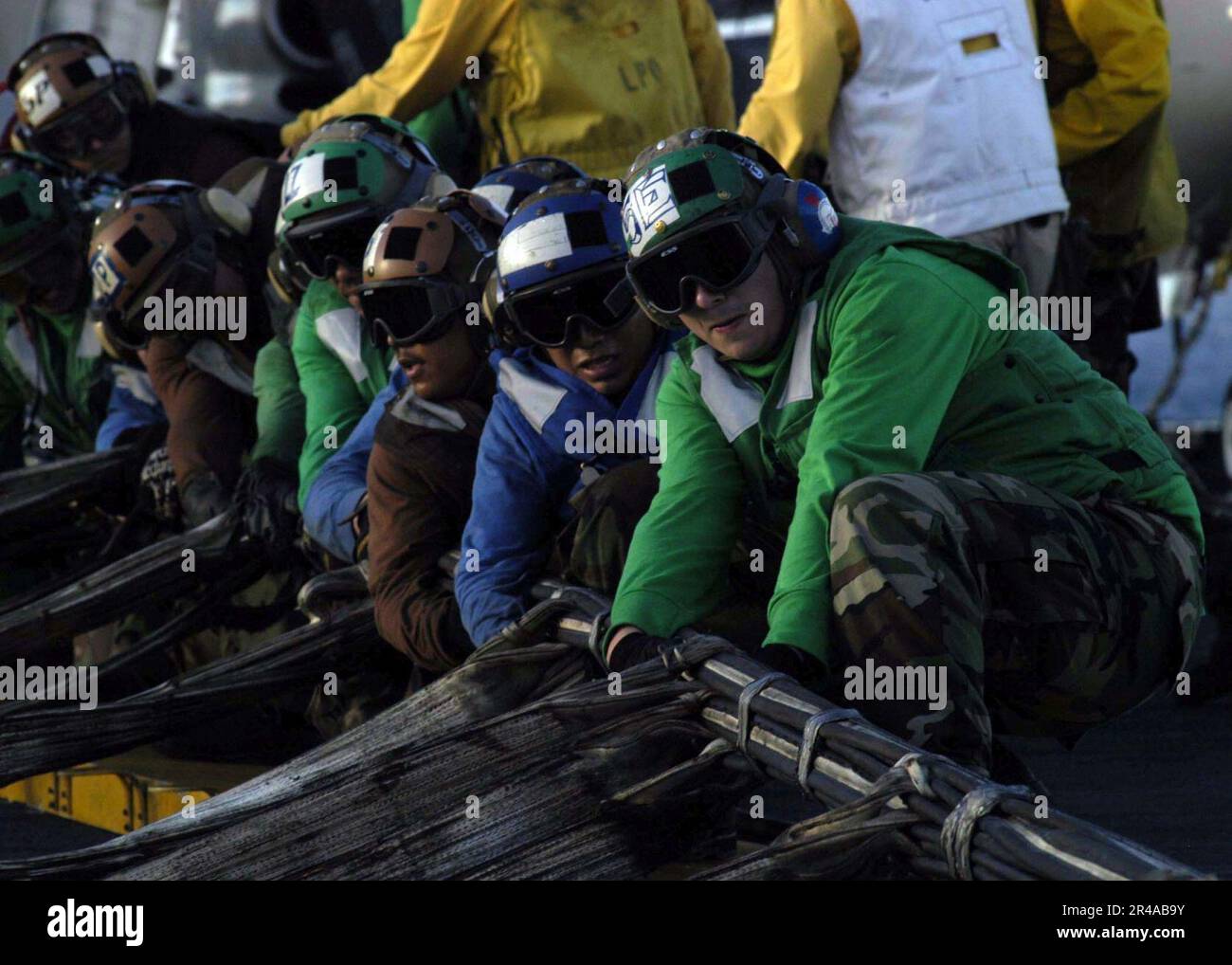 US Navy Flight deck personnel work together to rig the emergency