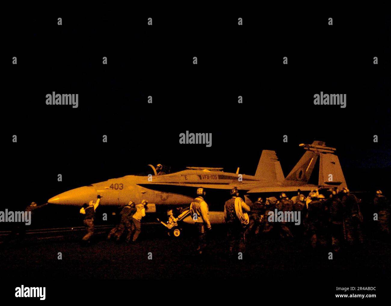US Navy Flight deck personnel push back an F-A-18C Hornet on the flight ...