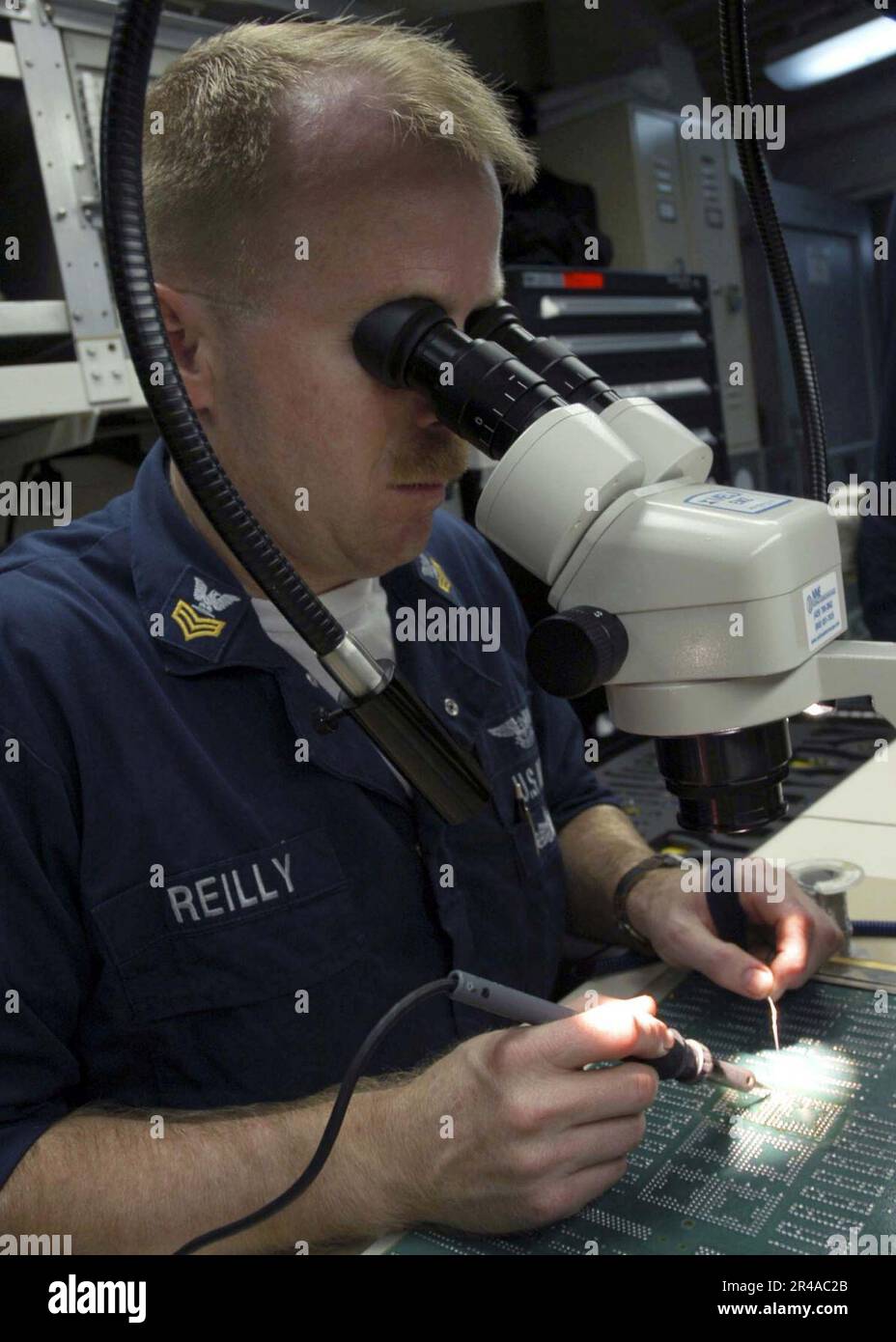 US Navy Aviation Electronics Technician 1st Class solders a set of