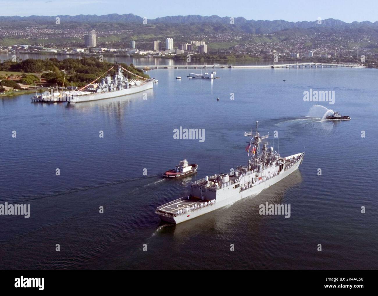 US Navy The guided Frigate USS Crommelin (FFG 37) passes the USS Missouri battleship and USS Arizona Memorials while returning to her homeport at Pearl Harbor, Hawaii Stock Photo