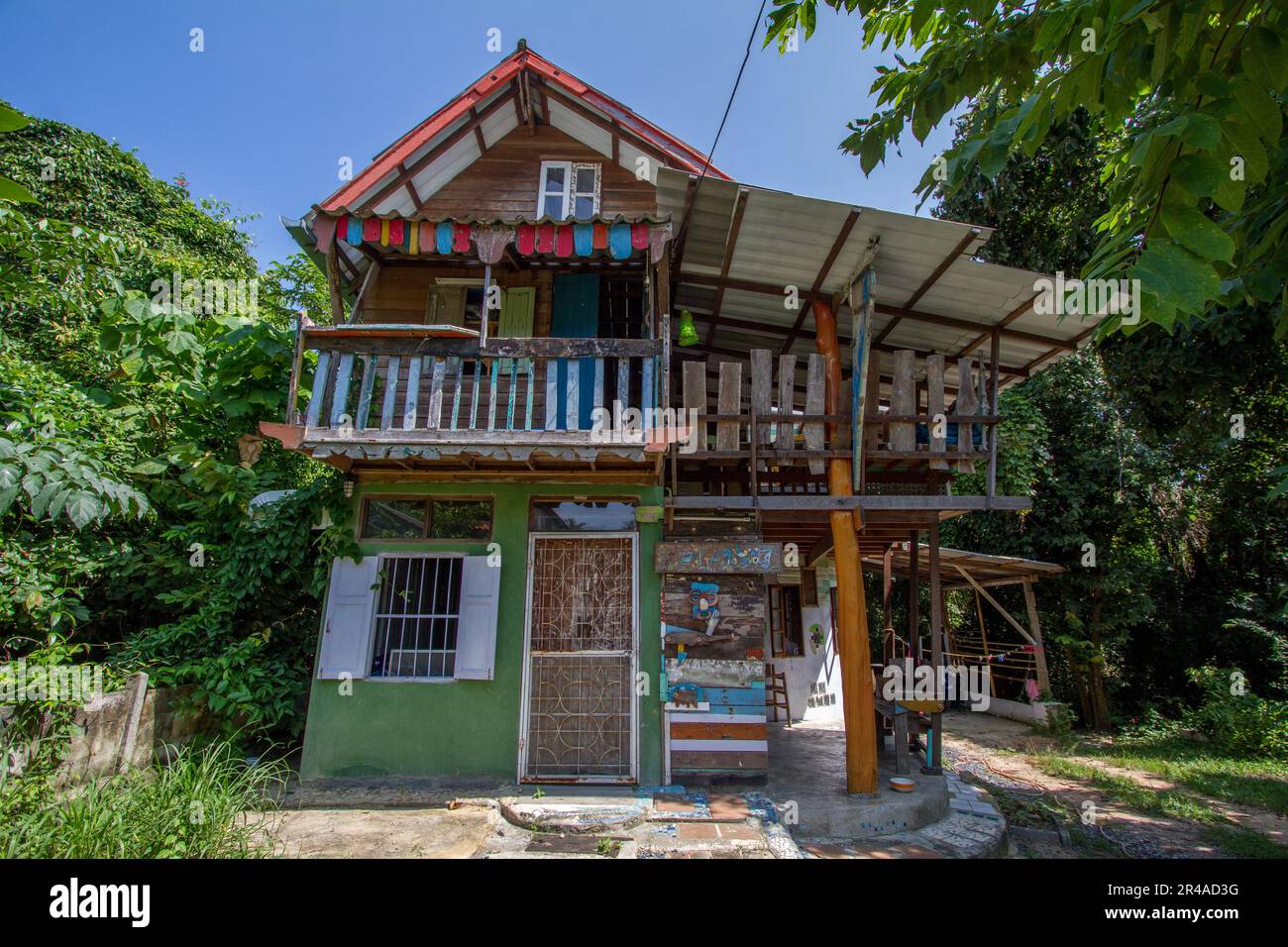 An aged two-story house with a wrap-around balcon. Stock Photo