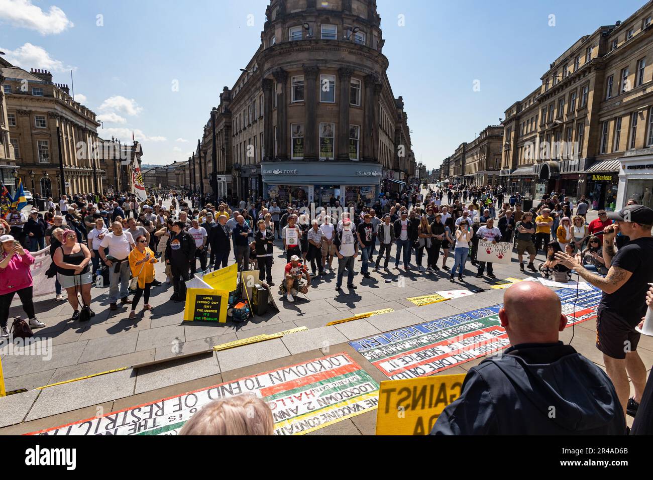 A diverse group of people walking down a bustling urban street in the bright light of day in protest Stock Photo