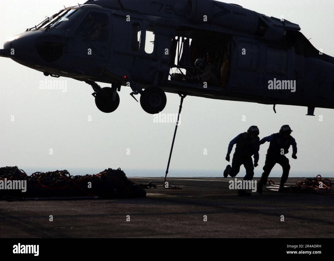 US Navy An MH60S Knighthawk helicopter prepares to lift a bundle of cargo nets from the Nimitz