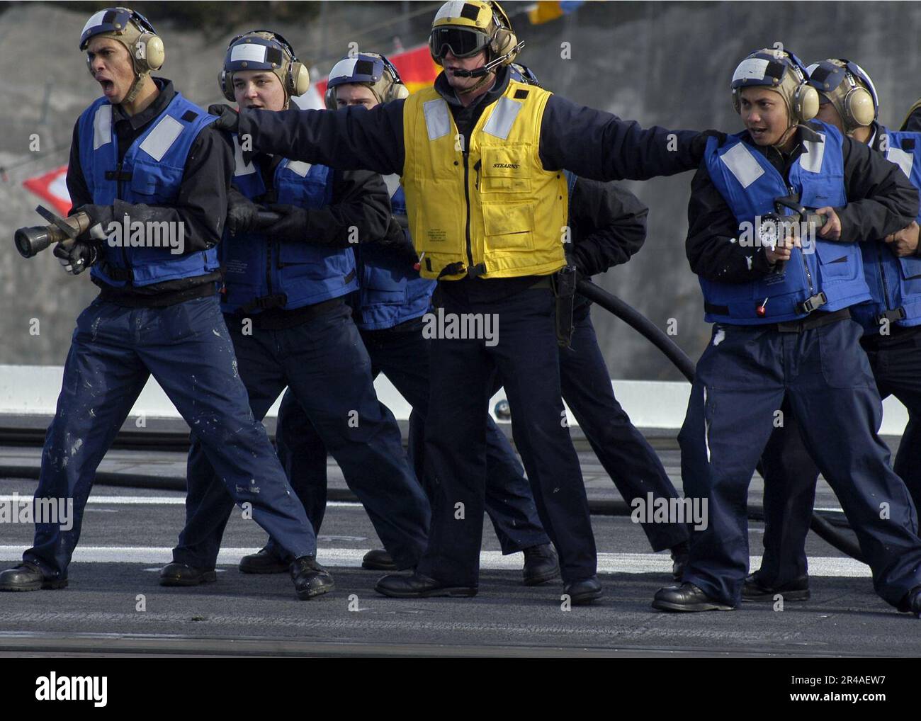 US Navy Sailors stand ready with fire hoses during an emergencylanding