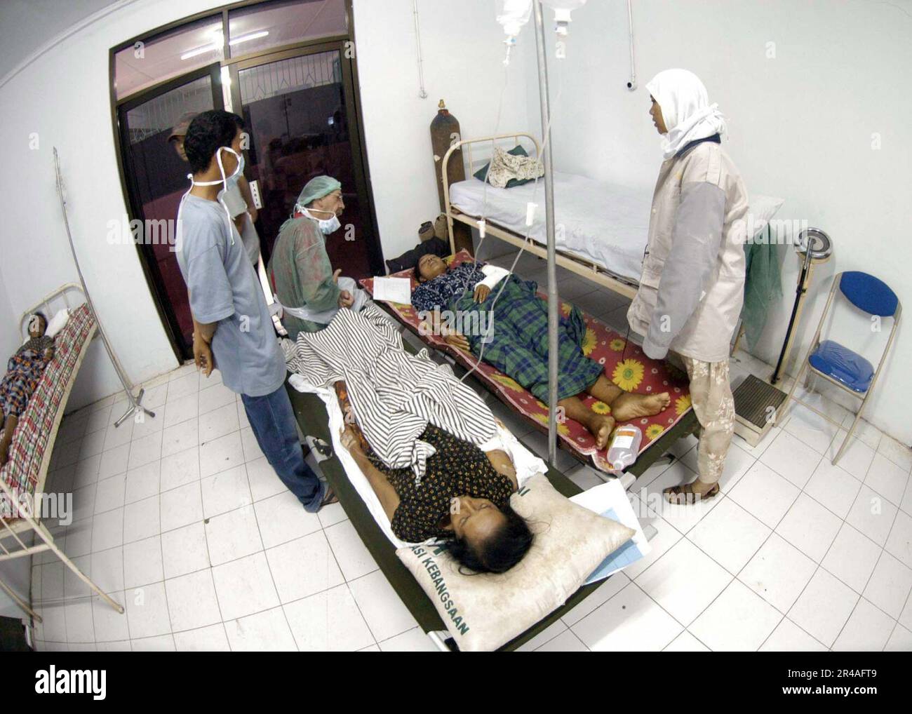 US Navy Dr. Paul Shumack from Brisband, Australia comforts a patient, after surgery on a wound she sustained during the Tsunami that hit coastal region of Aceh, Sumatra, Indonesia Stock Photo