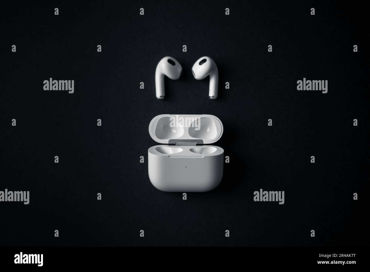 Two white Apple Airpods placed side by side on a black background Stock ...