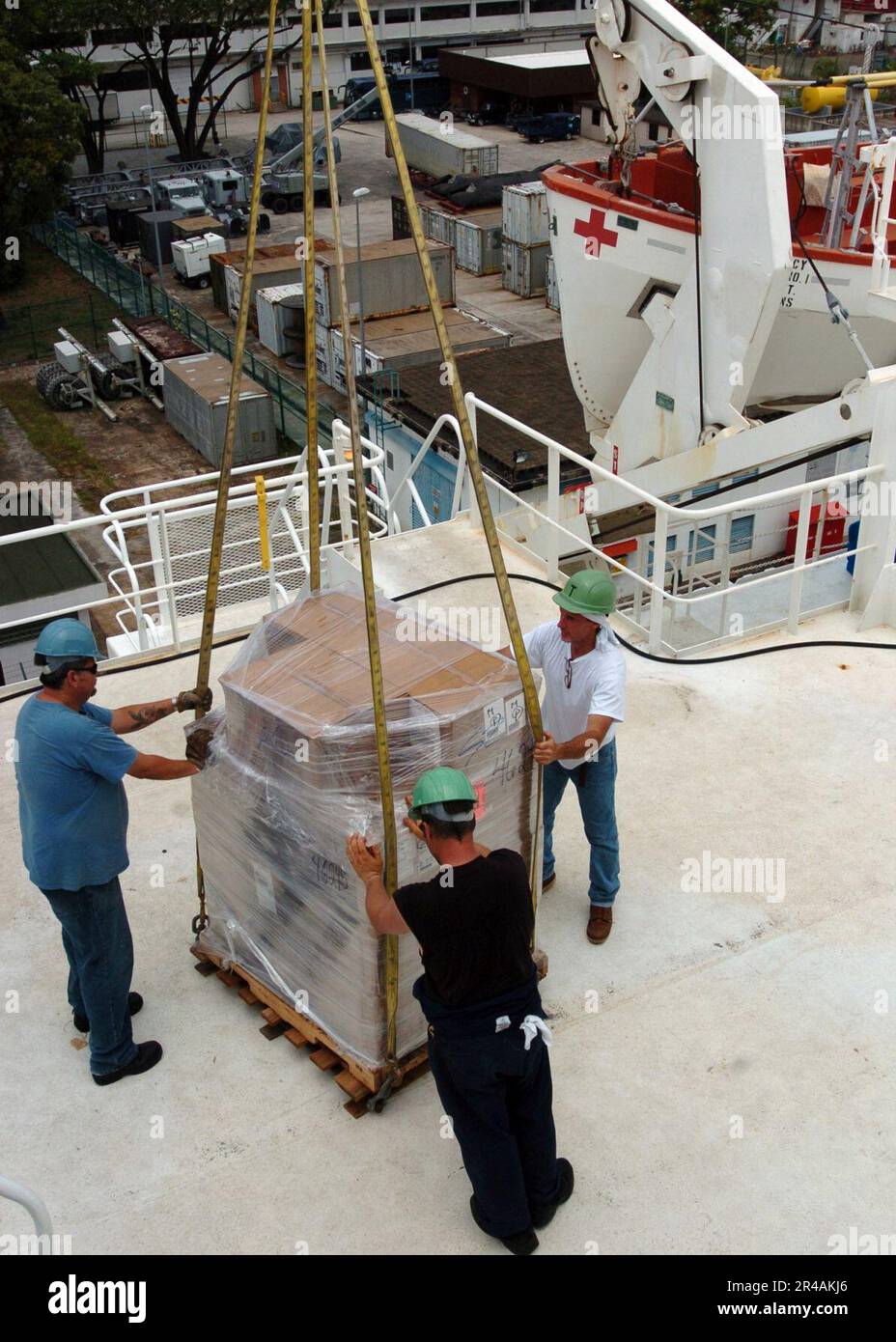 US Navy Civilian Mariners load cargo onto the Military Sealift Command