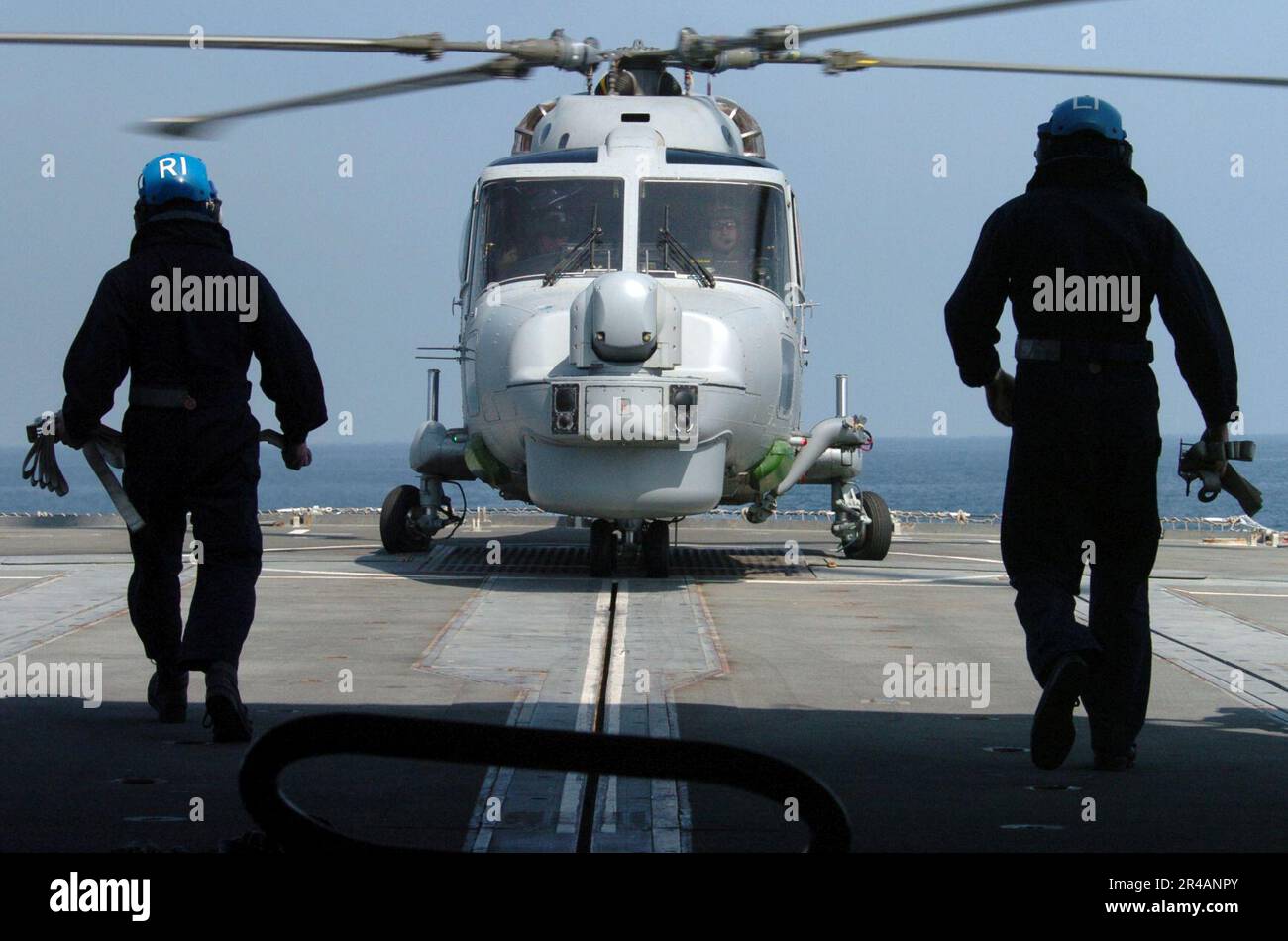 US Navy Two Royal Navy Sailors prepare to chain-down a Royal Navy Lynx Mk8 helicopter, assigned to 815 Squadron aboard the Royal Navy Type 23 frigate HMS Grafton (F80) Stock Photo