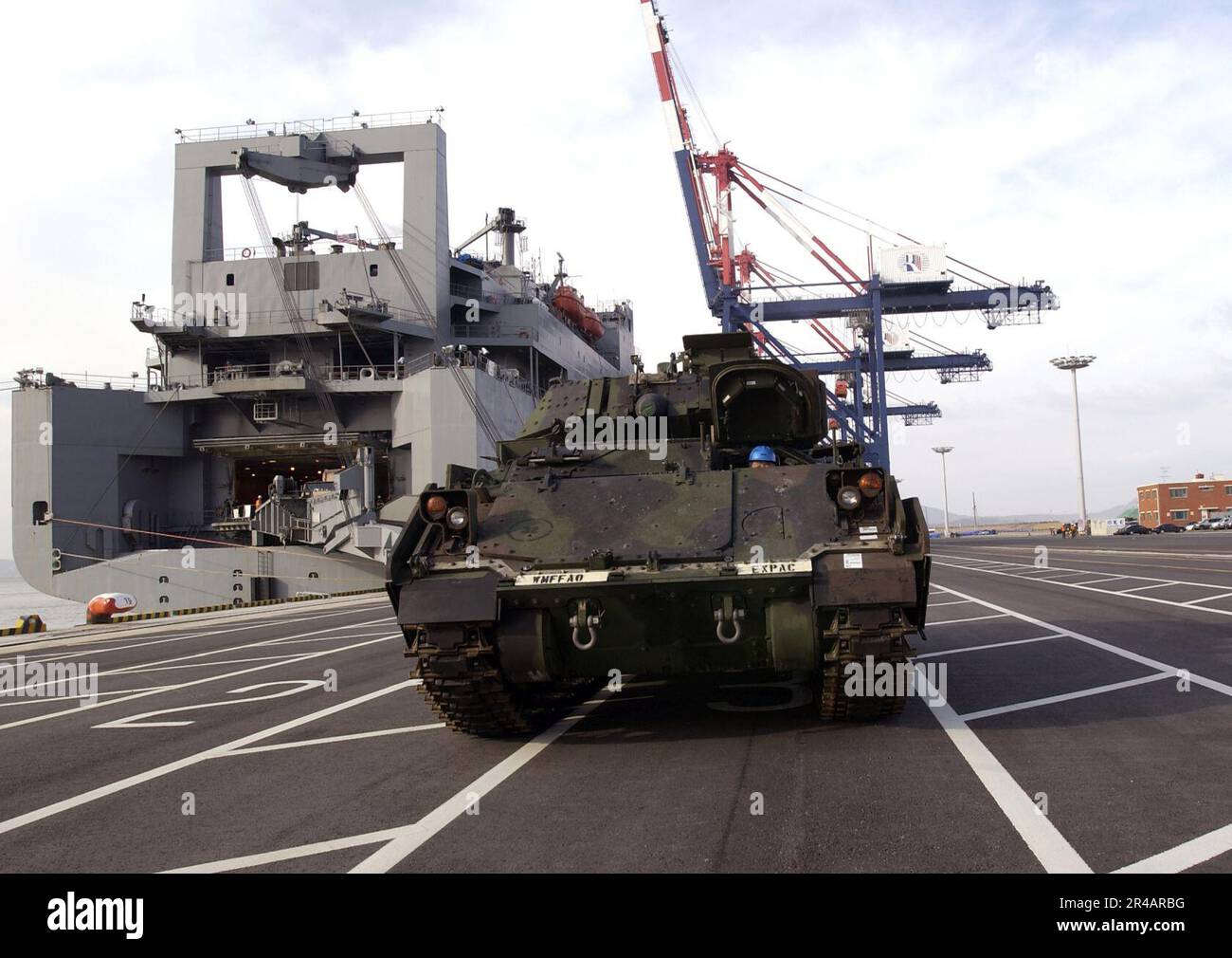 US Navy  An M2A3 Bradley Fighting Vehicle is prepared for loading aboard the Military Sealift Command (MSC) roll-on-roll-off ship USNS Watson (T-AKR 310). Stock Photo