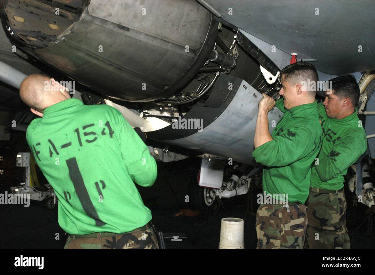 US Navy Aviation Machinist's Mates prepare to close an engine bay door