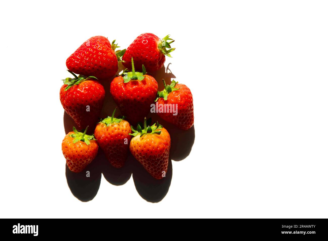 Strawberries isolated on a white background with stark shadows Stock ...