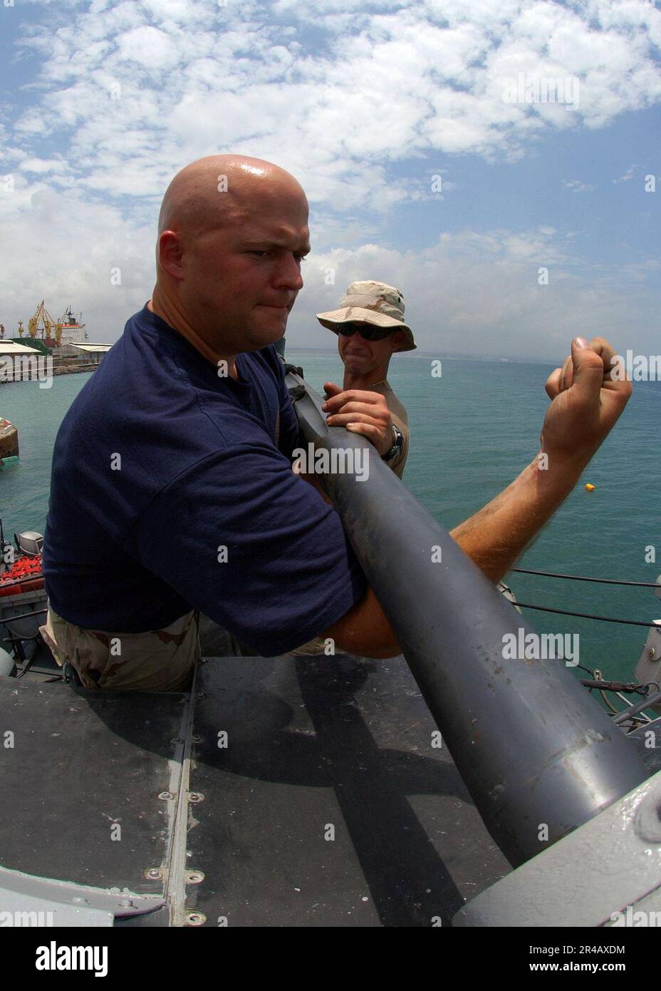 US Navy Gunners Mate 2nd Class and Gunner's Mate Seamen clean the ...