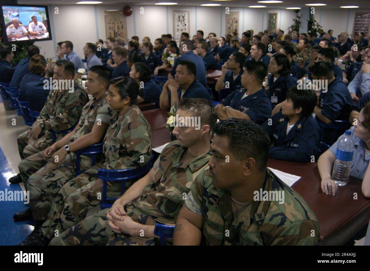 US Navy  Crew members watch via video teleconference as Chief of Naval Operations Adm. Vern Clark and Master Chief Petty Officer of the Navy Terry Scott congratulate the crew. Stock Photo