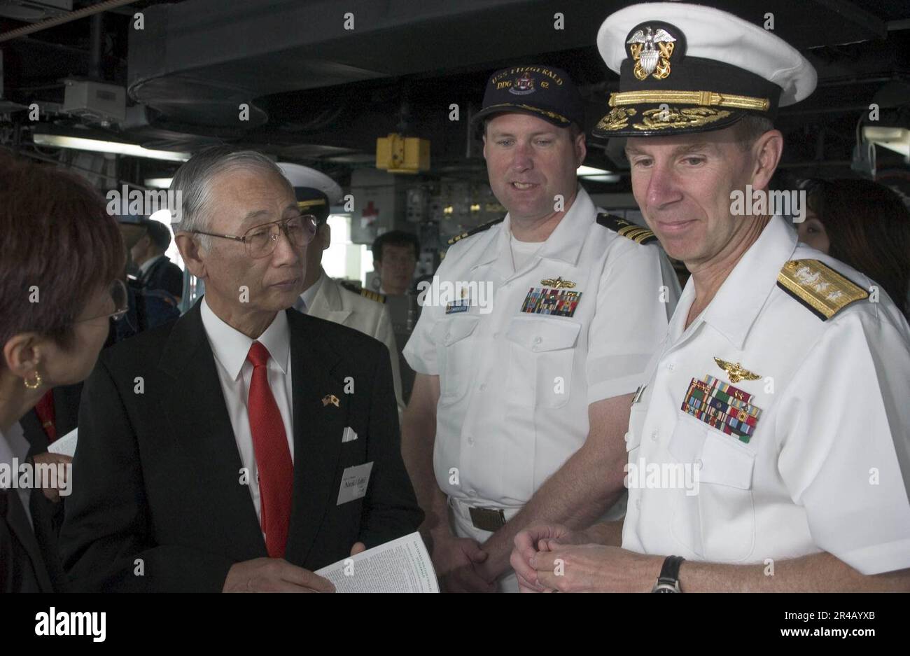 US Navy Commander Brad Smith, center, explains operations on the bridge ...