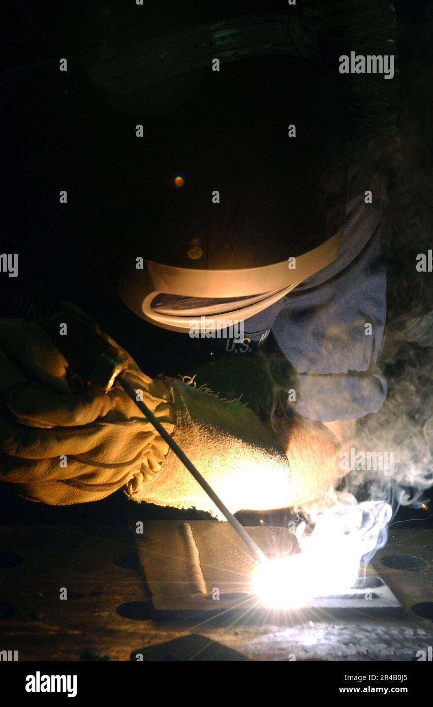 US Navy Hull Technician Fireman practices welding techniques aboard the ...