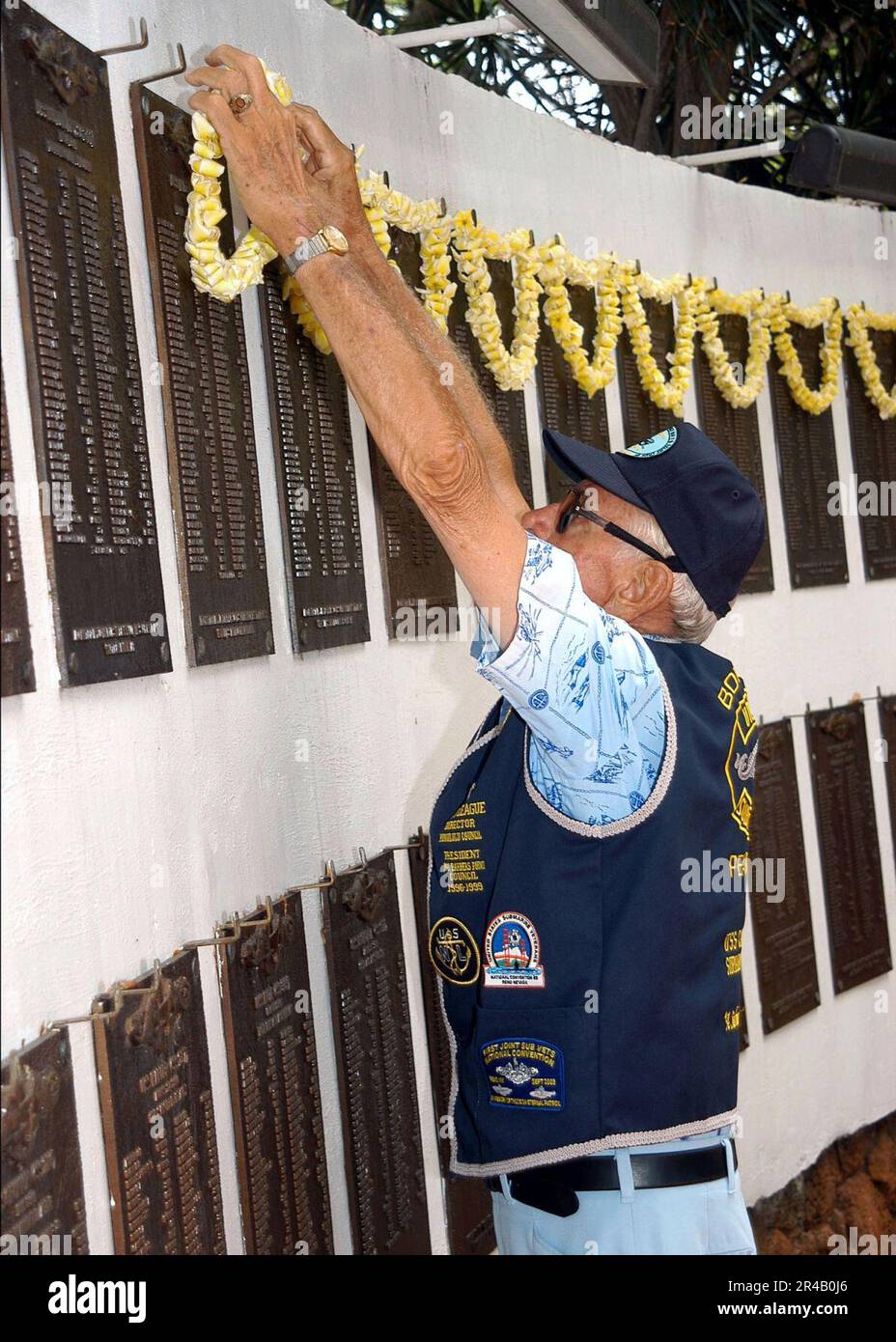 US Navy United States Navy (Ret.), Yeoman 1st Class places a lei in