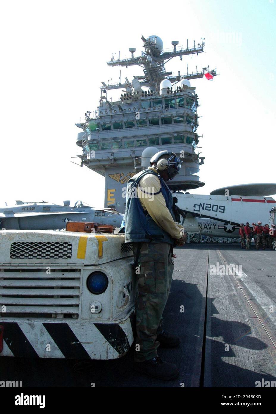 US Navy An aviation Boatswain's Mate stands next to his assigned