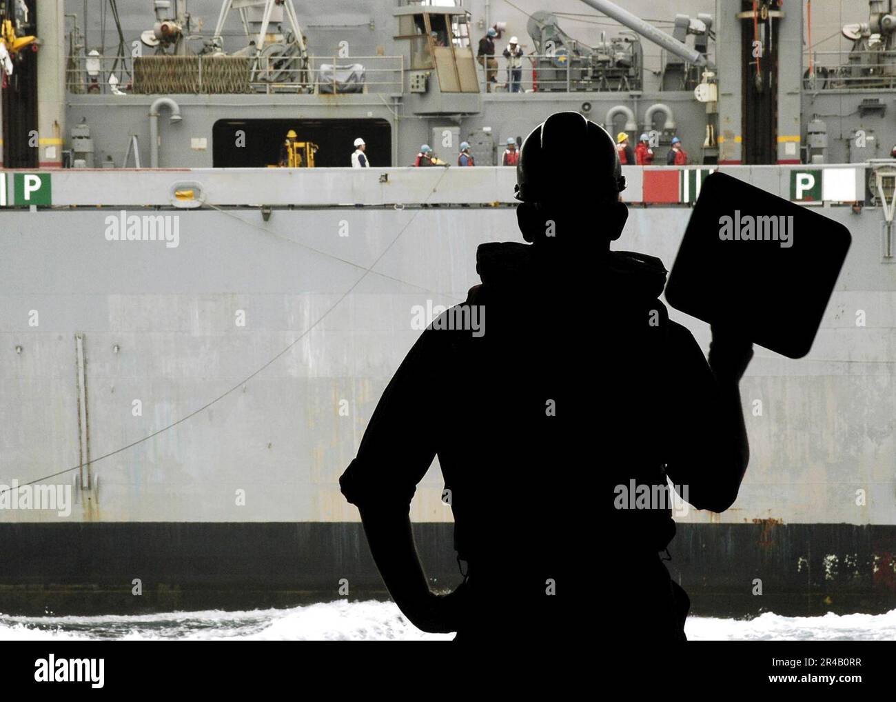 US Navy Boatswain's Mate Seaman acts as line signalman during an