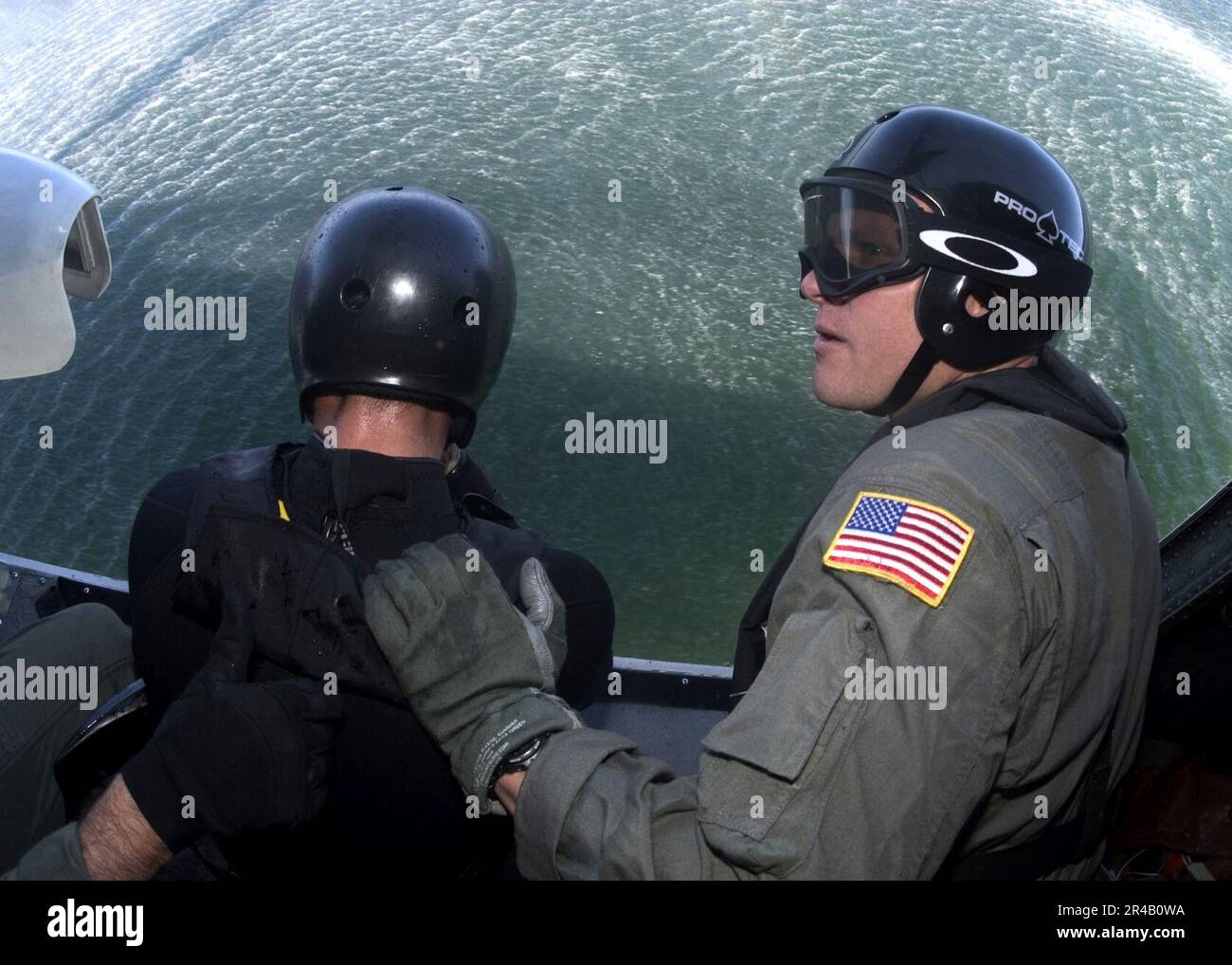 US Navy Aviation Boatswains Mate 1st Class left, stands by to receive a okay to jump signal