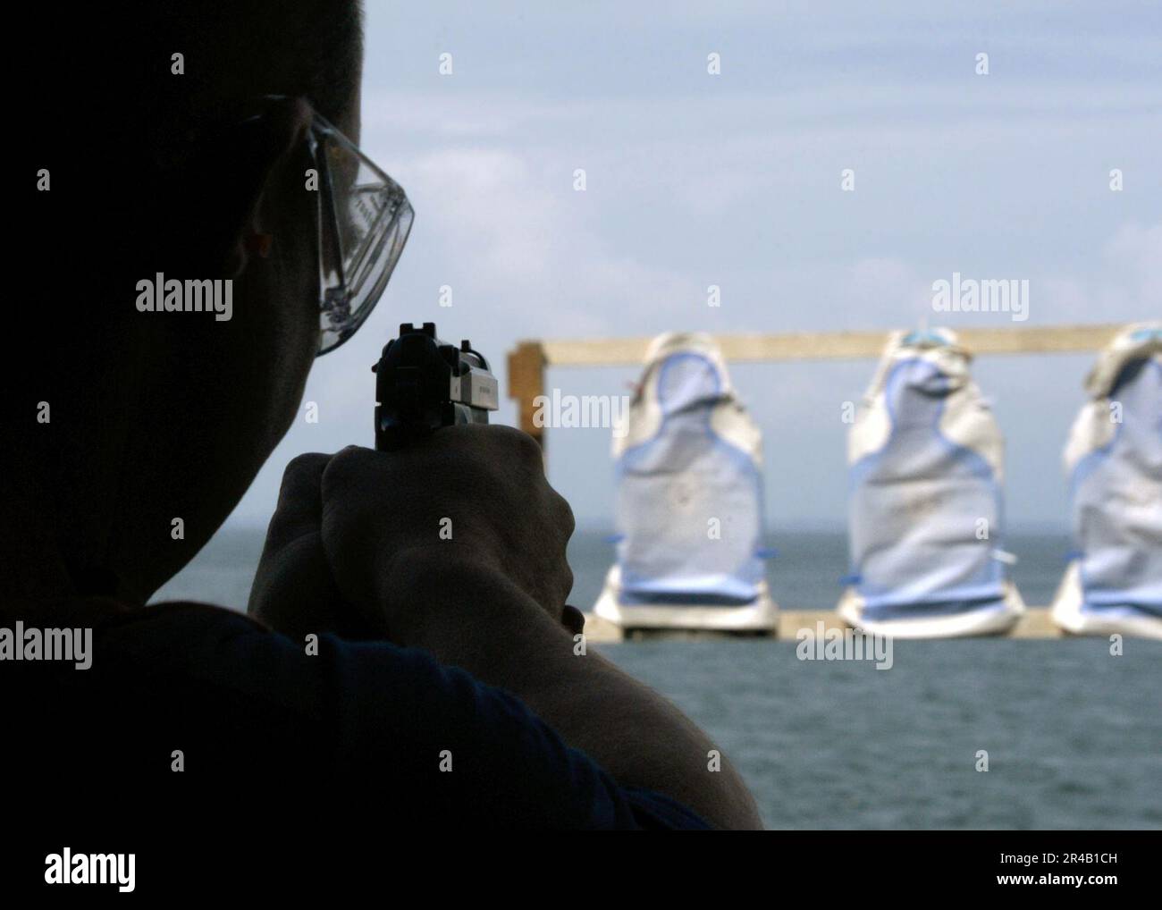 US Navy Photographer's Mate 1st Class takes aim at his target during a