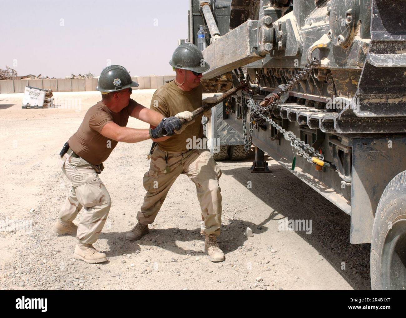 US Navy U.S. Navy Equipment Operators tighten chains that are holding a