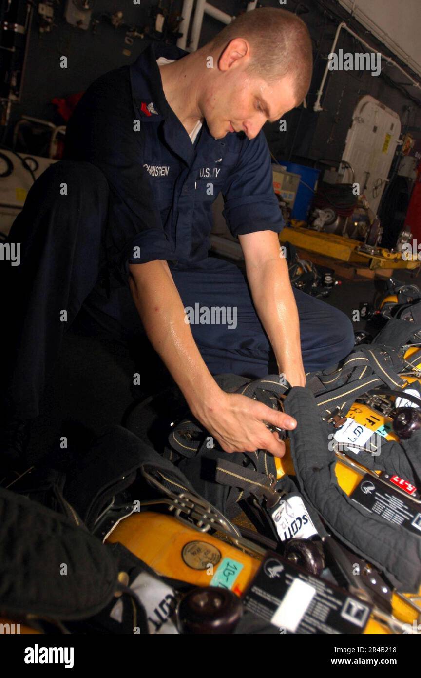 US Navy Damage Controlman 1st Class refills a SelfContained Breathing
