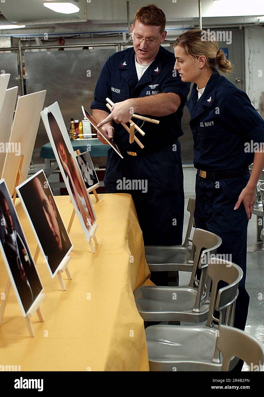 US Navy Photographer's Mate 2nd Class discuses one of Photographer's