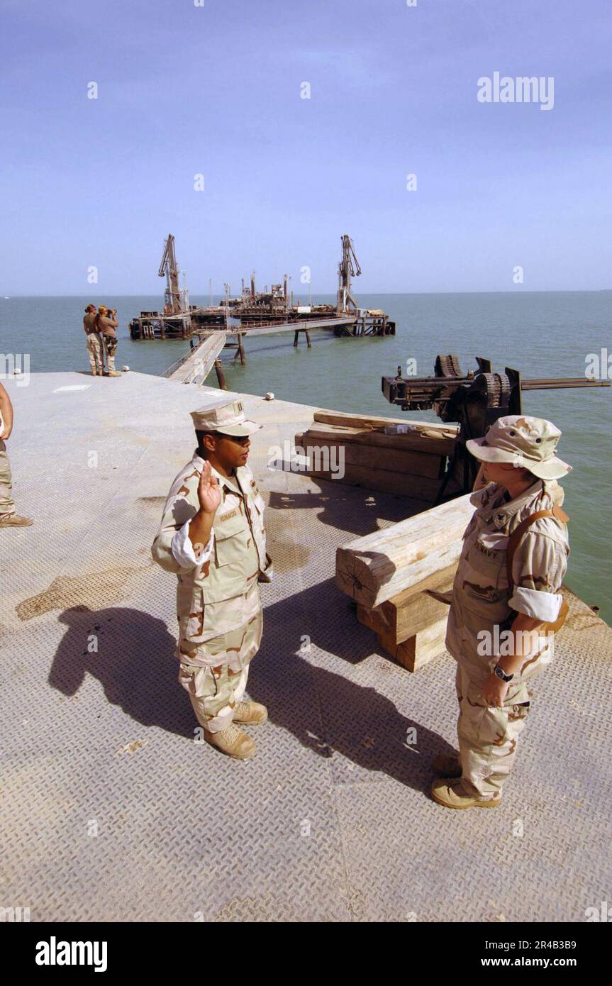 Furthermost US Navy Master-at-arms 3rd class takes the oath of re-enlistment on the ...