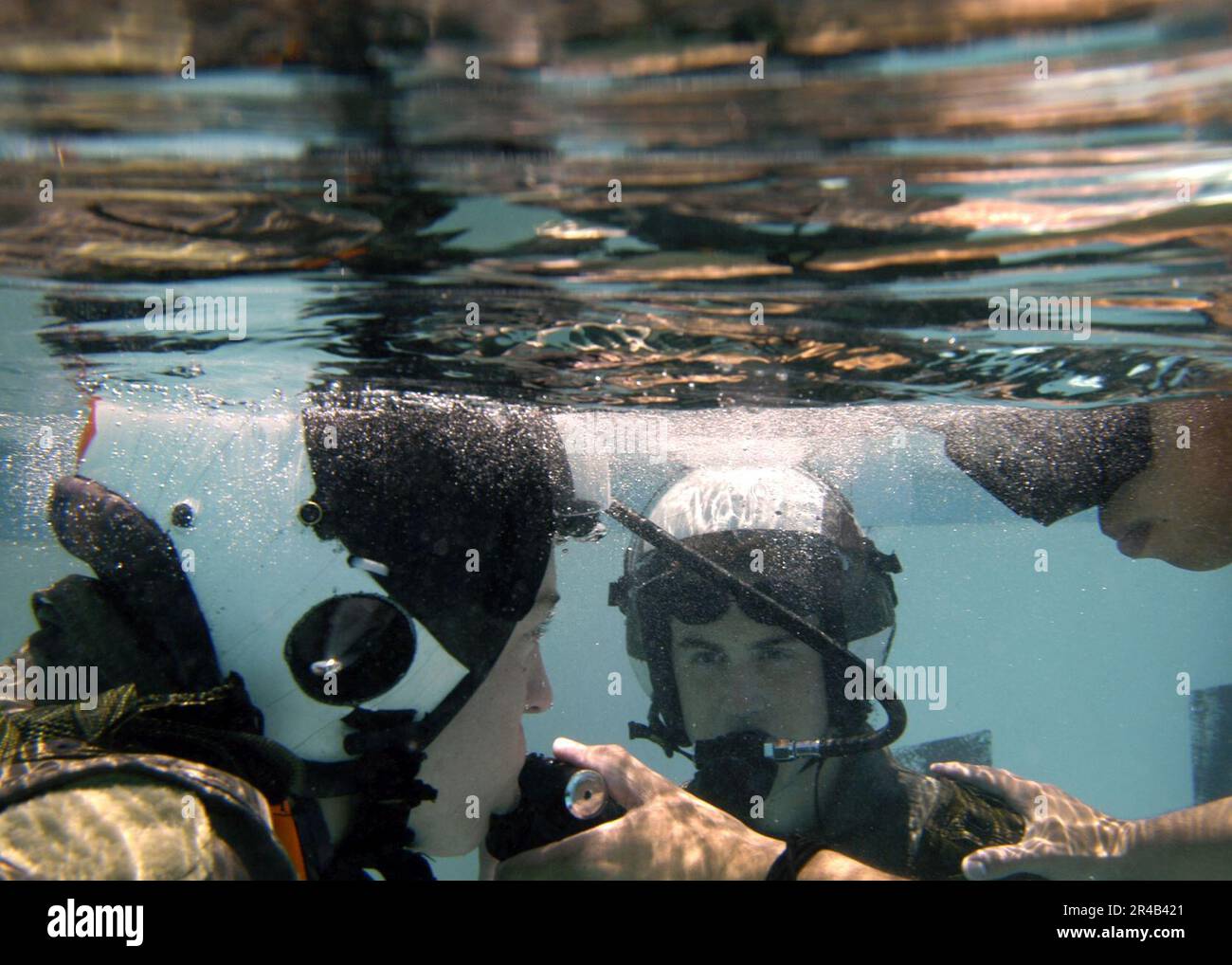 US Navy  Two students submerge and breathe from SCUBA tanks as part of a familiarization course in the use of the Helicopter Emergency Escape Device at Aviation Survival Training Center. Stock Photo