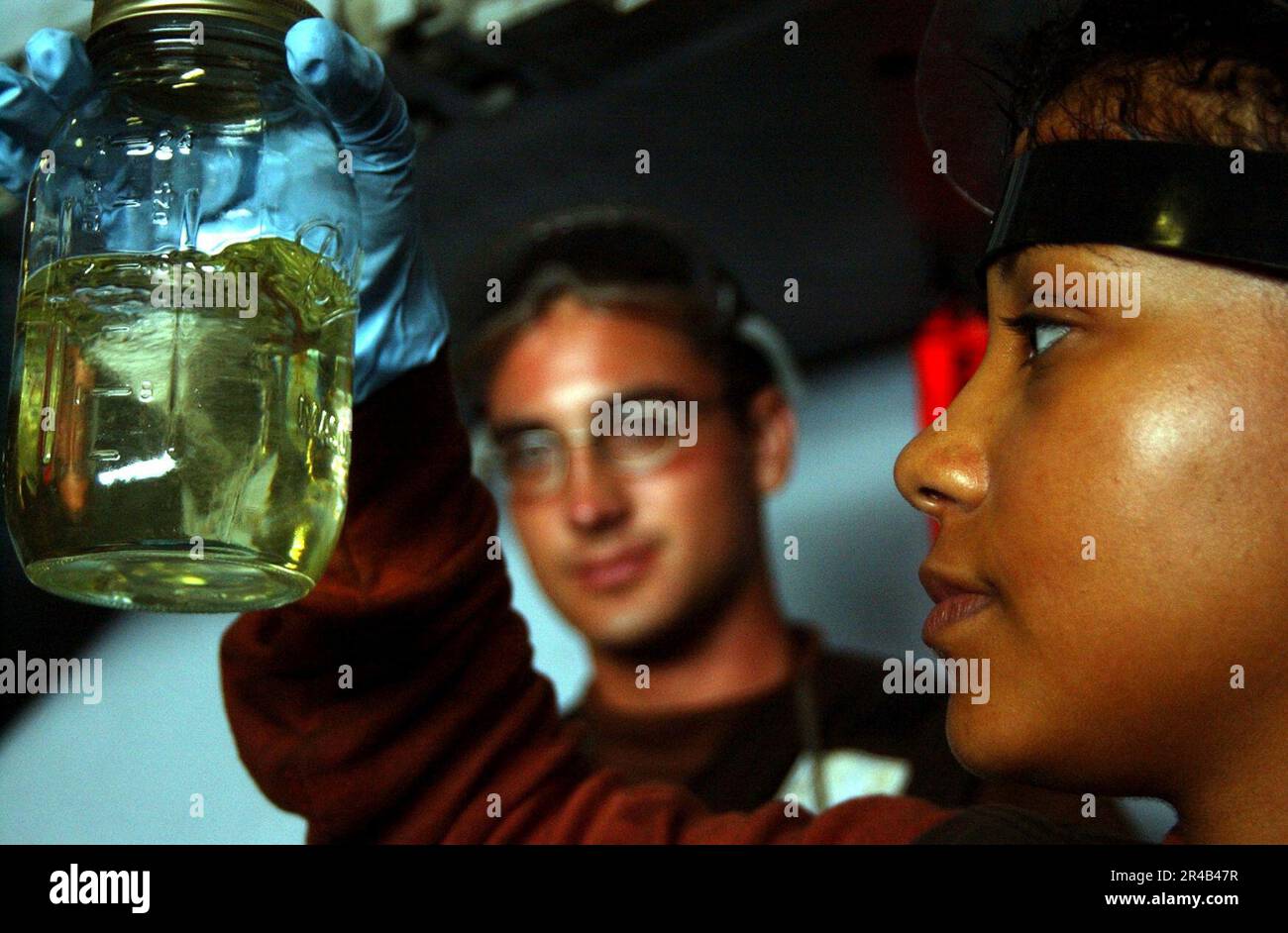 US Navy Airman inspects a sample of JP5 jet fuel from an FA18