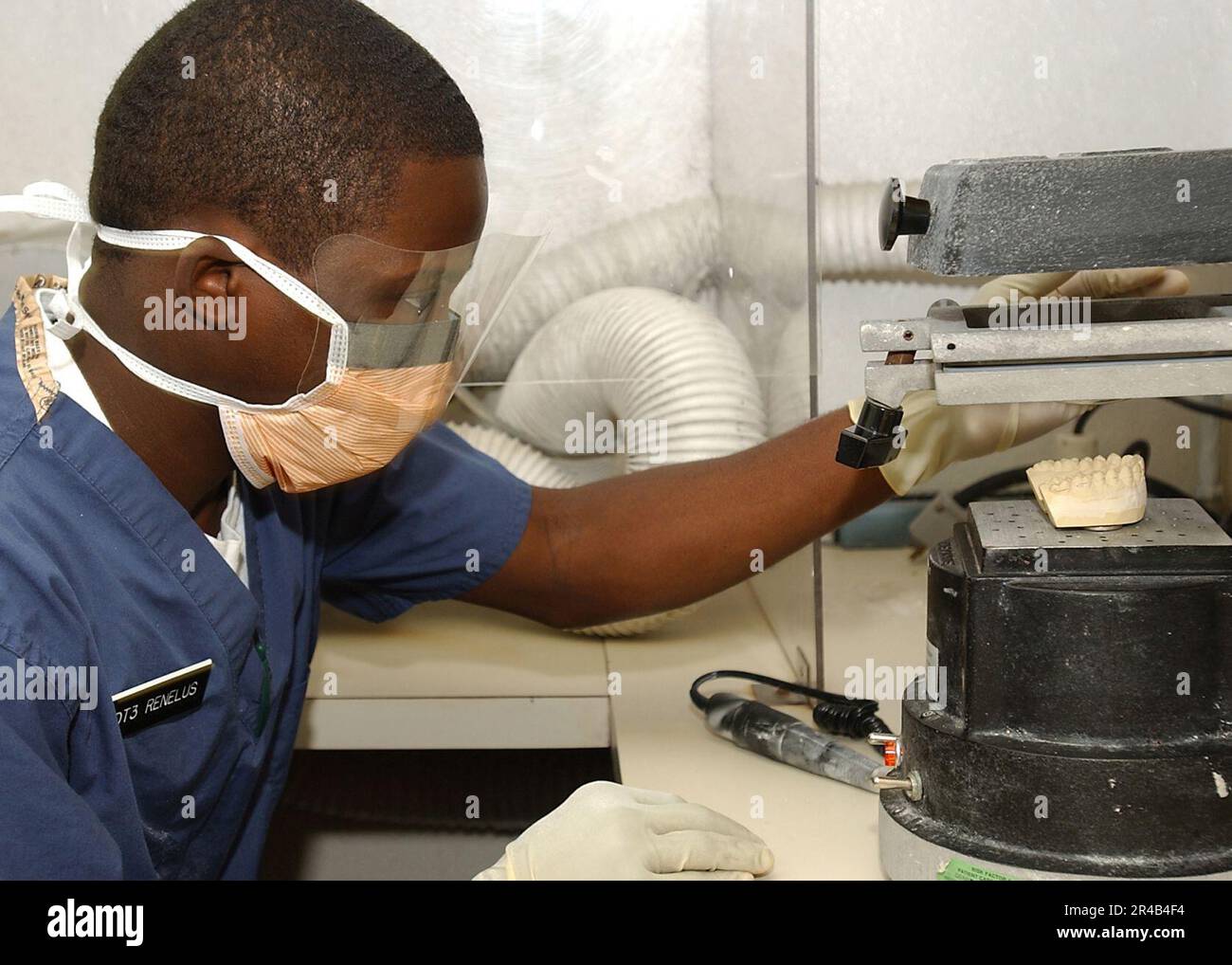 US Navy Dental Technician 3rd Class uses a vacuum to hold down teeth