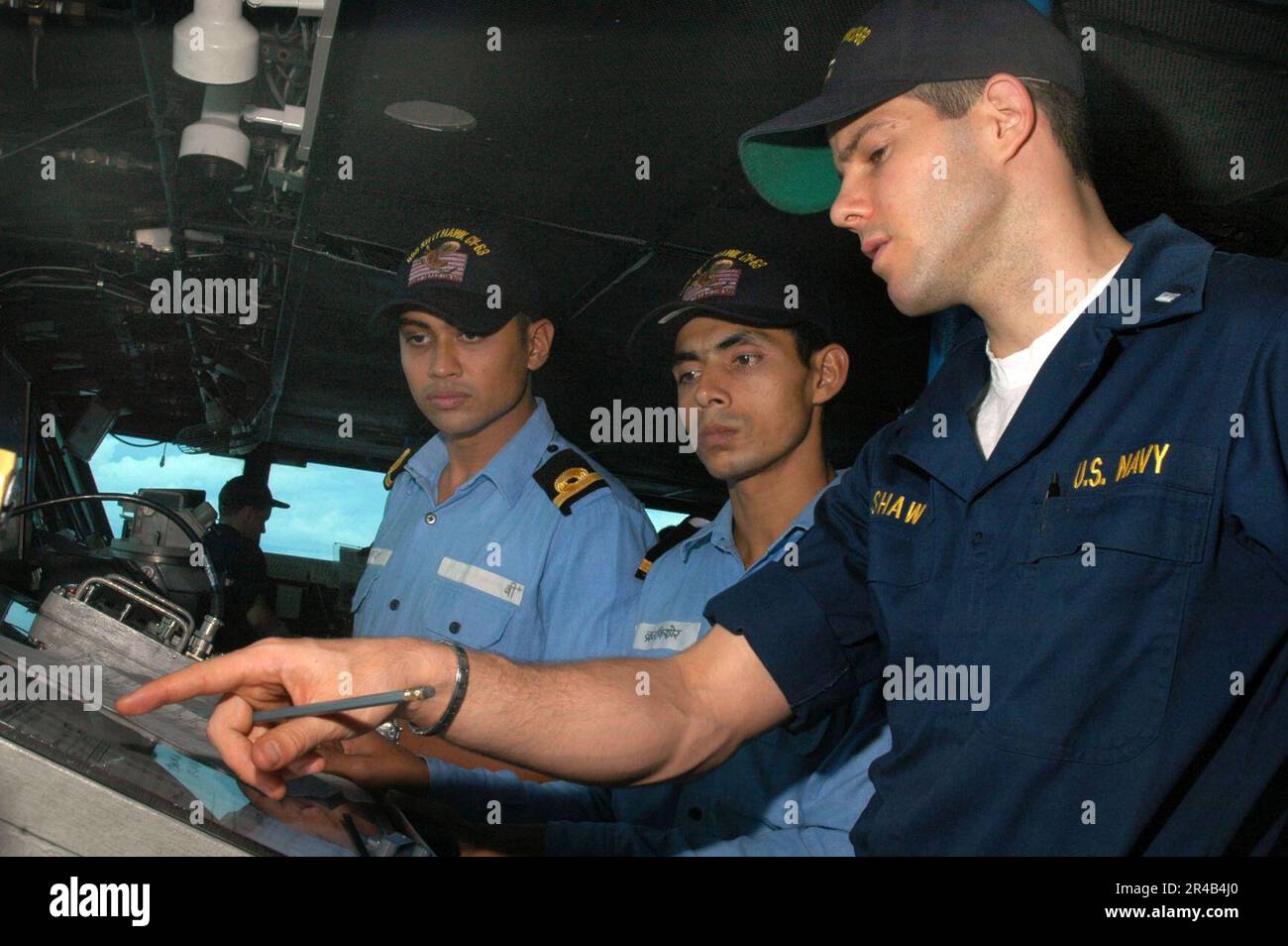 US Navy  Junior Officer of the Watch, Lt.j.g. right, reviews operating procedures on the bridge aboard the conventionally powered aircraft carrier USS Kitty Hawk (CV 63). Stock Photo