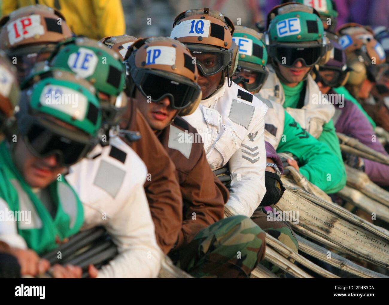 US Navy Several flight deck personnel wait for the orders to rig a ...