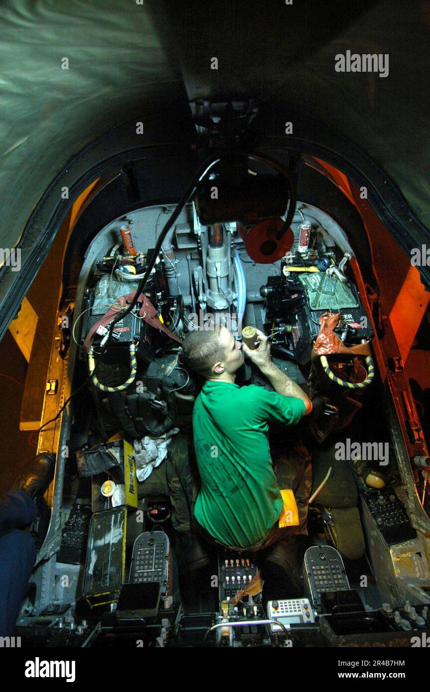 US Navy Aviation Structural Mechanic performs preventive maintenance on the ejection seats in
