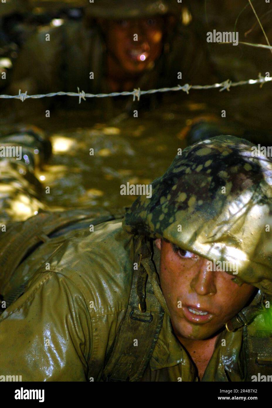 US Navy U.S. Navy Utilitiesman 3rd Class lowcrawls through mudfilled trenches as part of an