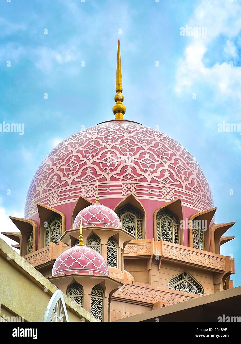 A pink-domed mosque stands out against a bright blue sky Stock Photo