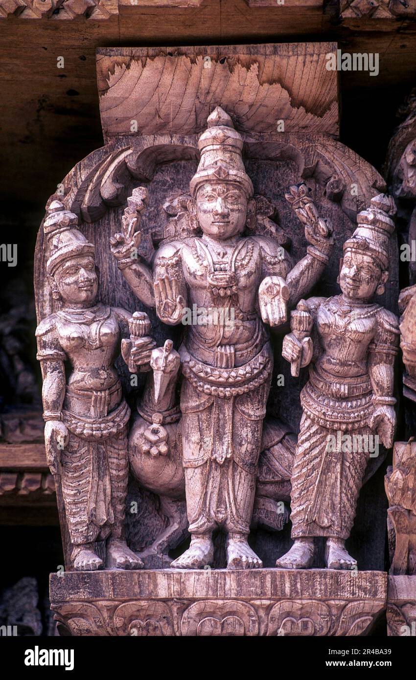 Loard Muruga with his consorts Valli and Deivanai, 17th century wooden carvings in Meenakshi-Sundareswarar temple Chariot at Madurai, Tamil Nadu Stock Photo