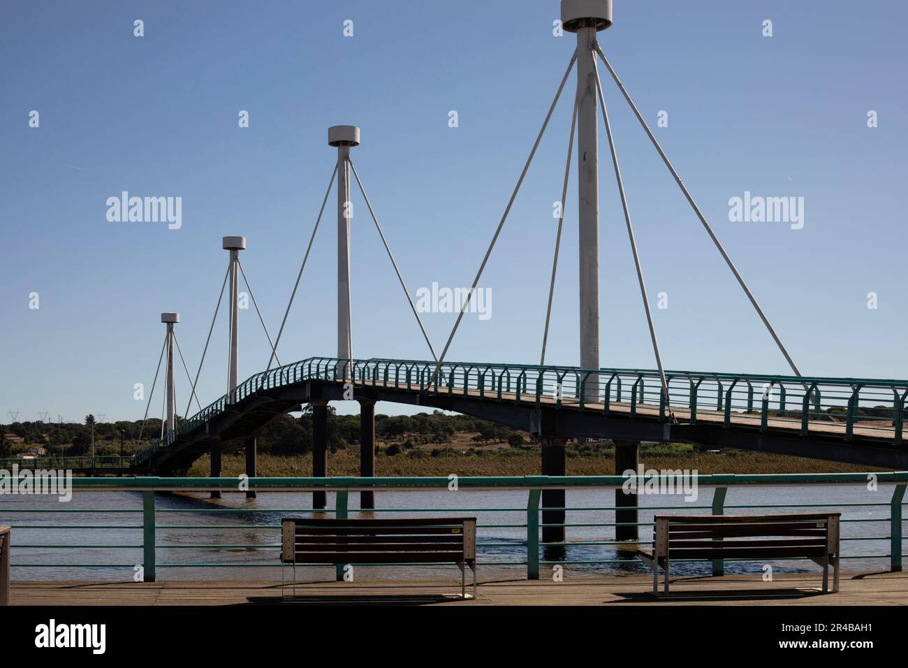 A picturesque bridge spans a body of water, with a dock visible in the foreground Stock Photo