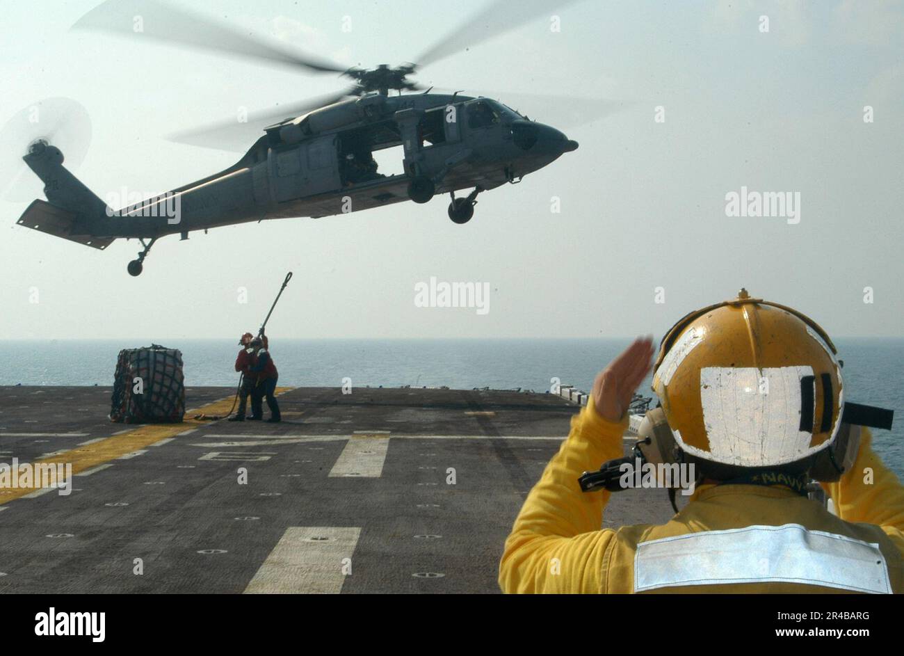 US Navy Aviation Boatswain's Mate 3rd Class directs a MH60S Seahawk