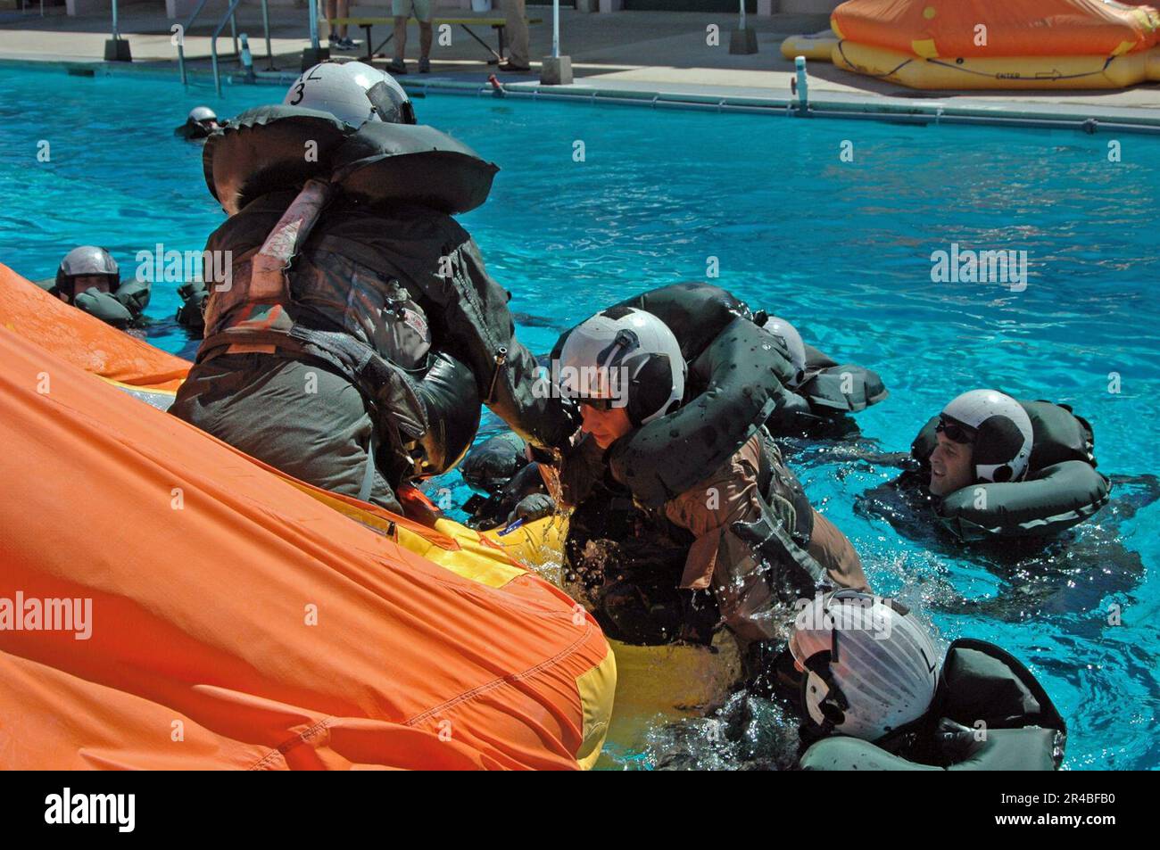 US Navy  Navy air crewman help each other into a 12-man life raft to await a simulated rescue in the pool at Aviation Survival Training Center (ASTC) Miramar. Stock Photo