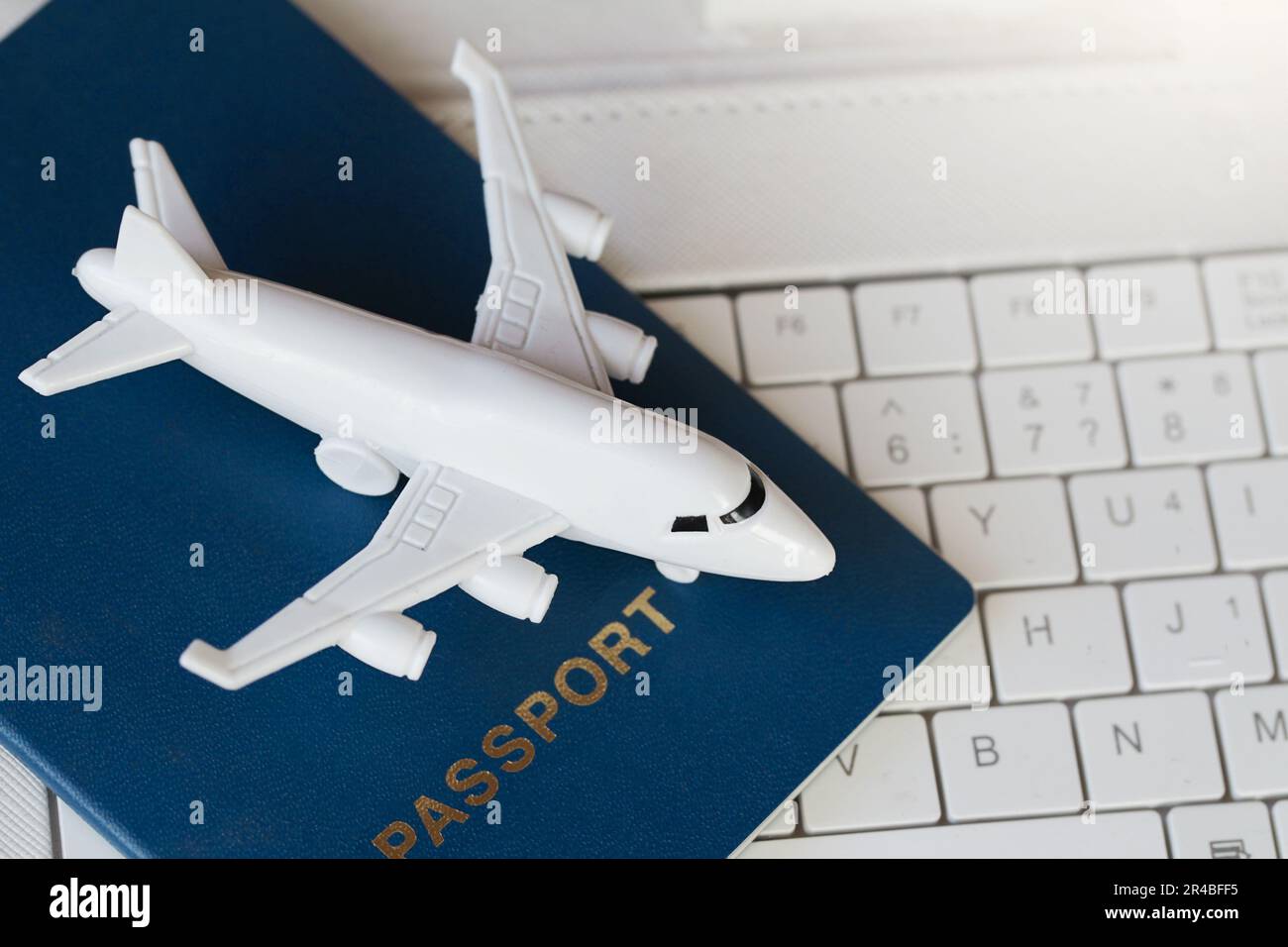 Model white airplane, white laptop and passport . Buying online ticket booking for travel concept Stock Photo