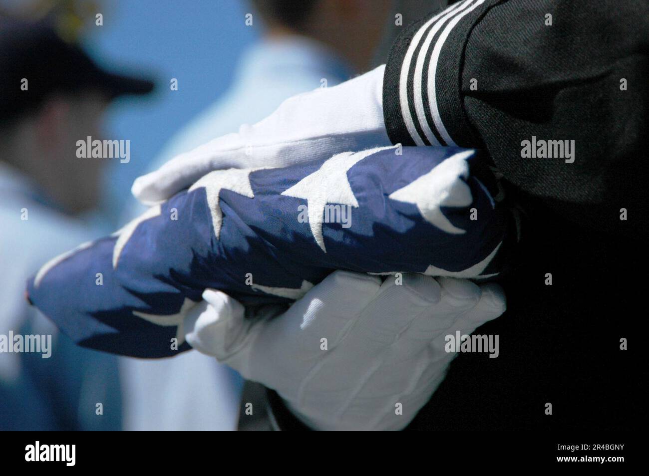 US Navy  A member of the flag detail prepares to present a folded American flag to Chief Aviation Boatswain's Mate at his retirement ceremony. Stock Photo