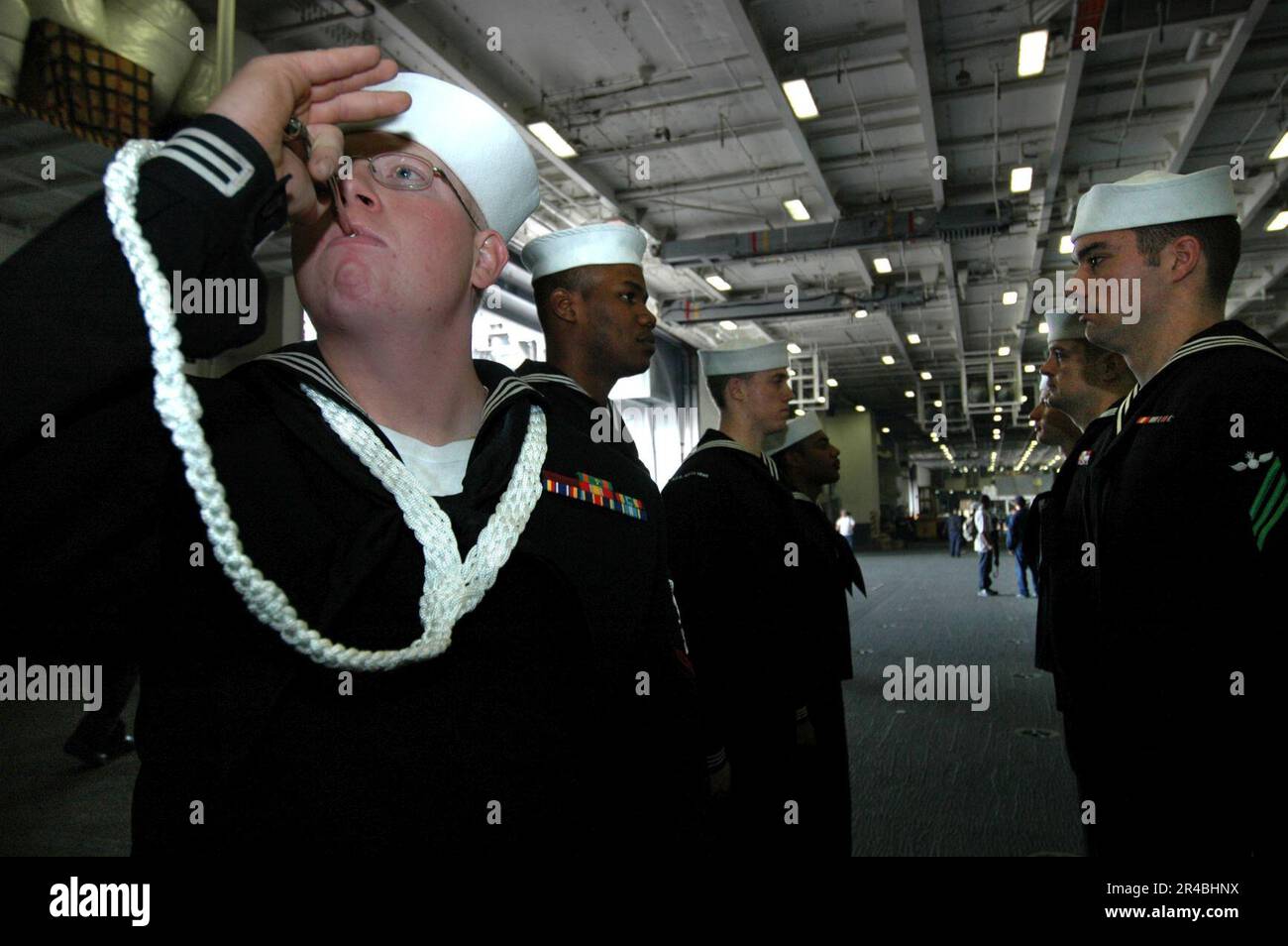 US Navy Boatswain's Mate 3rd Class sounds the boatswain's pipe during