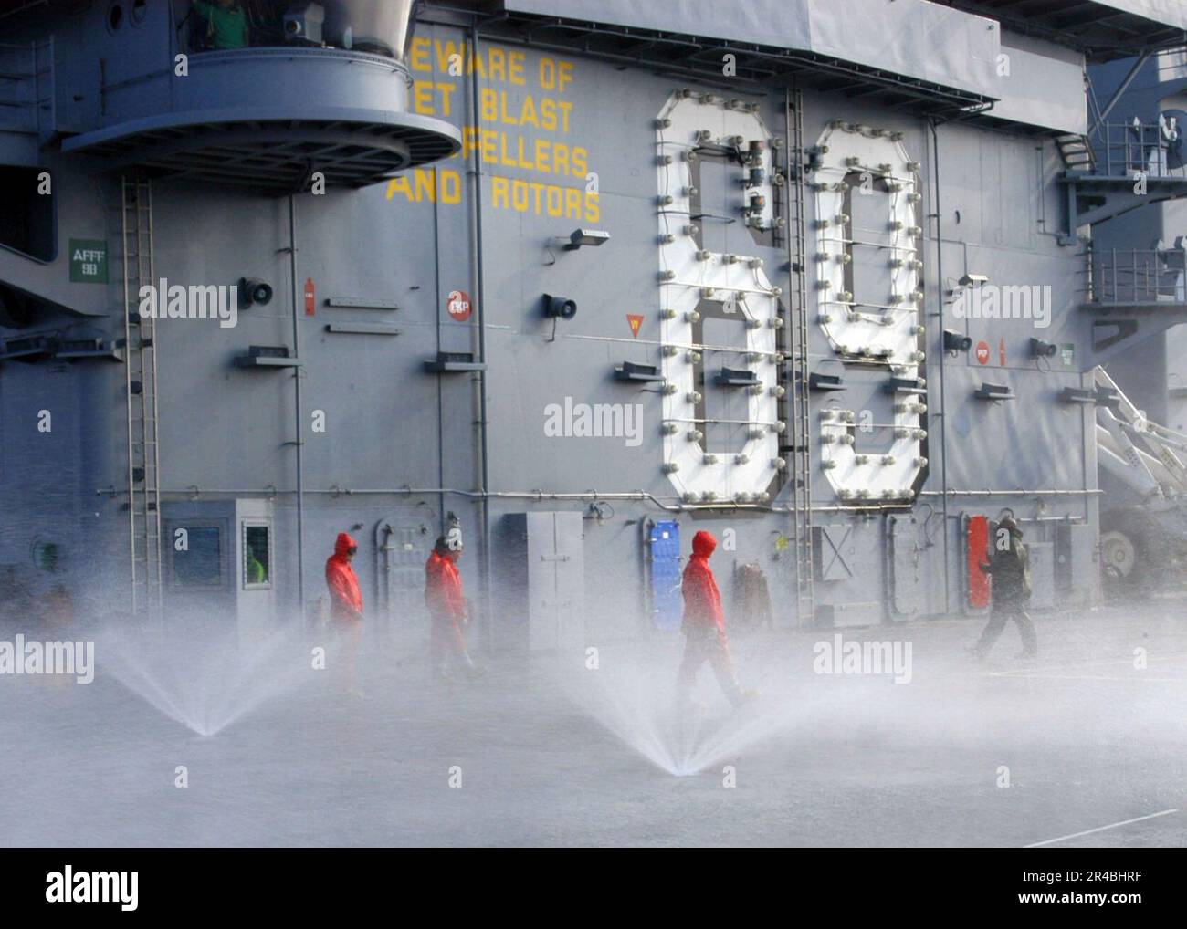 US Navy Air Department personnel check sprinklers on the flight deck ...